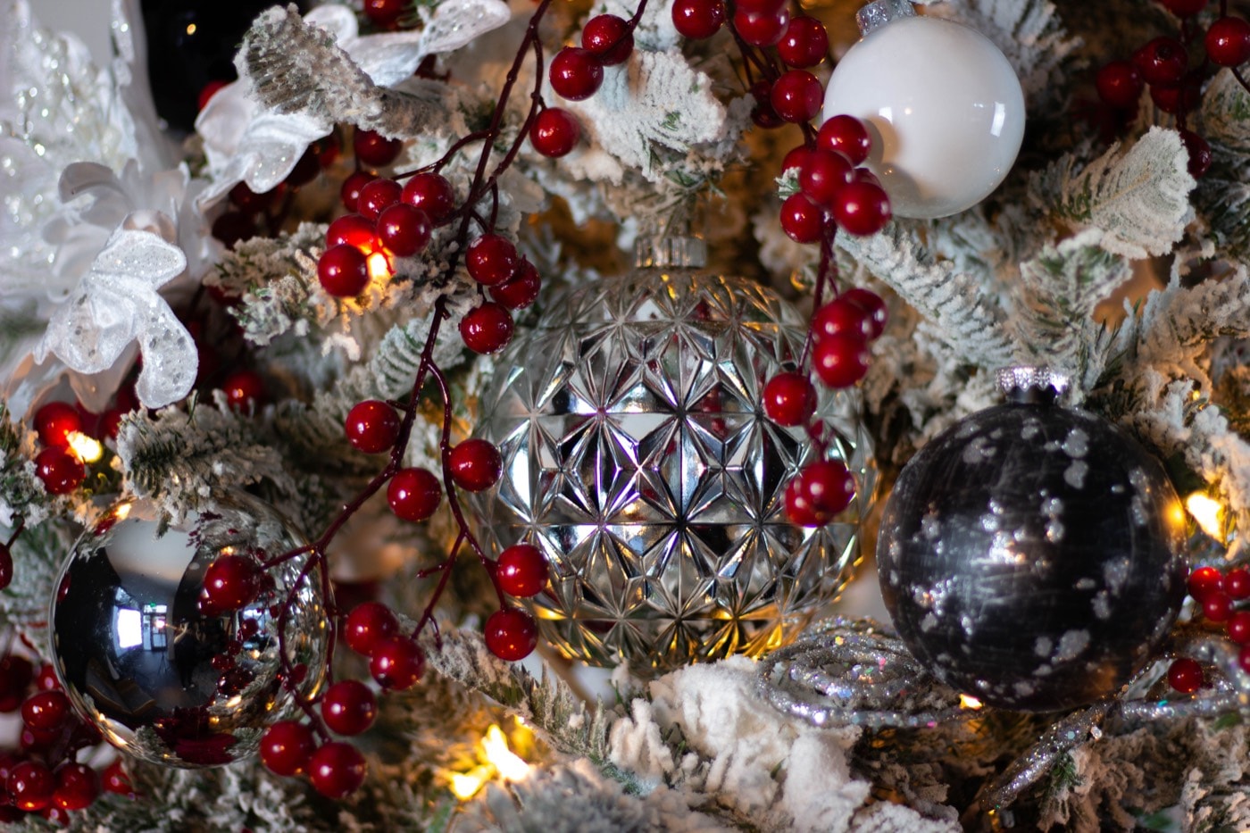 Faceted silver against red berry — the pairing the whole tree is composed around.